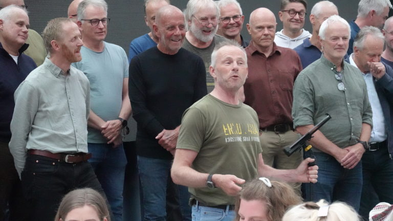 Ivar Kirkhus ledet et smilende kor